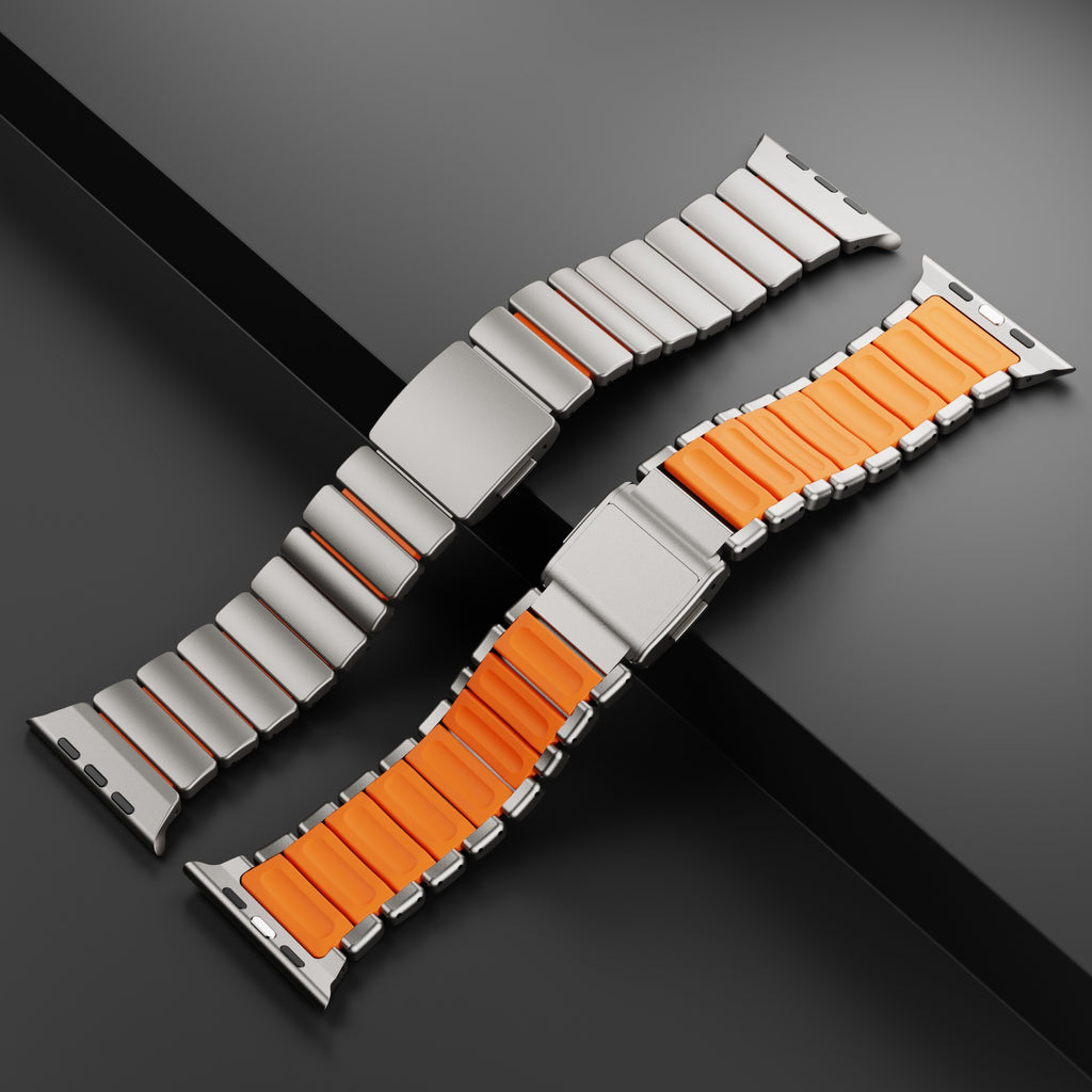 Titanium and orange silicone link bands on dark background