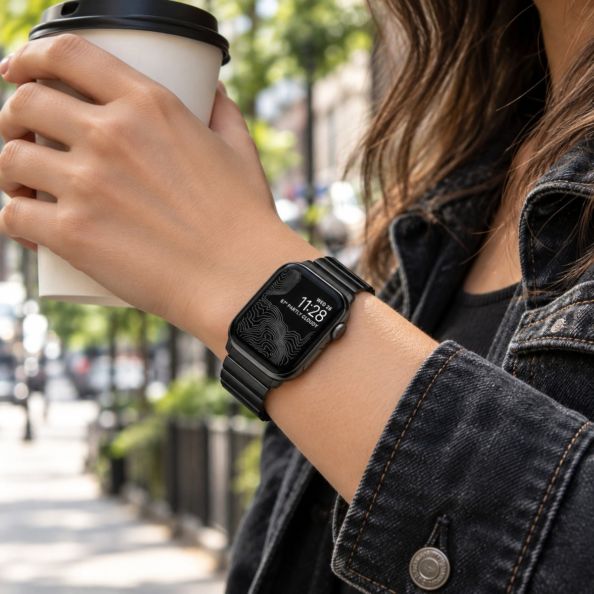 Flat-Link Titanium Band for Apple Watch, Black, worn on the wrist with coffee