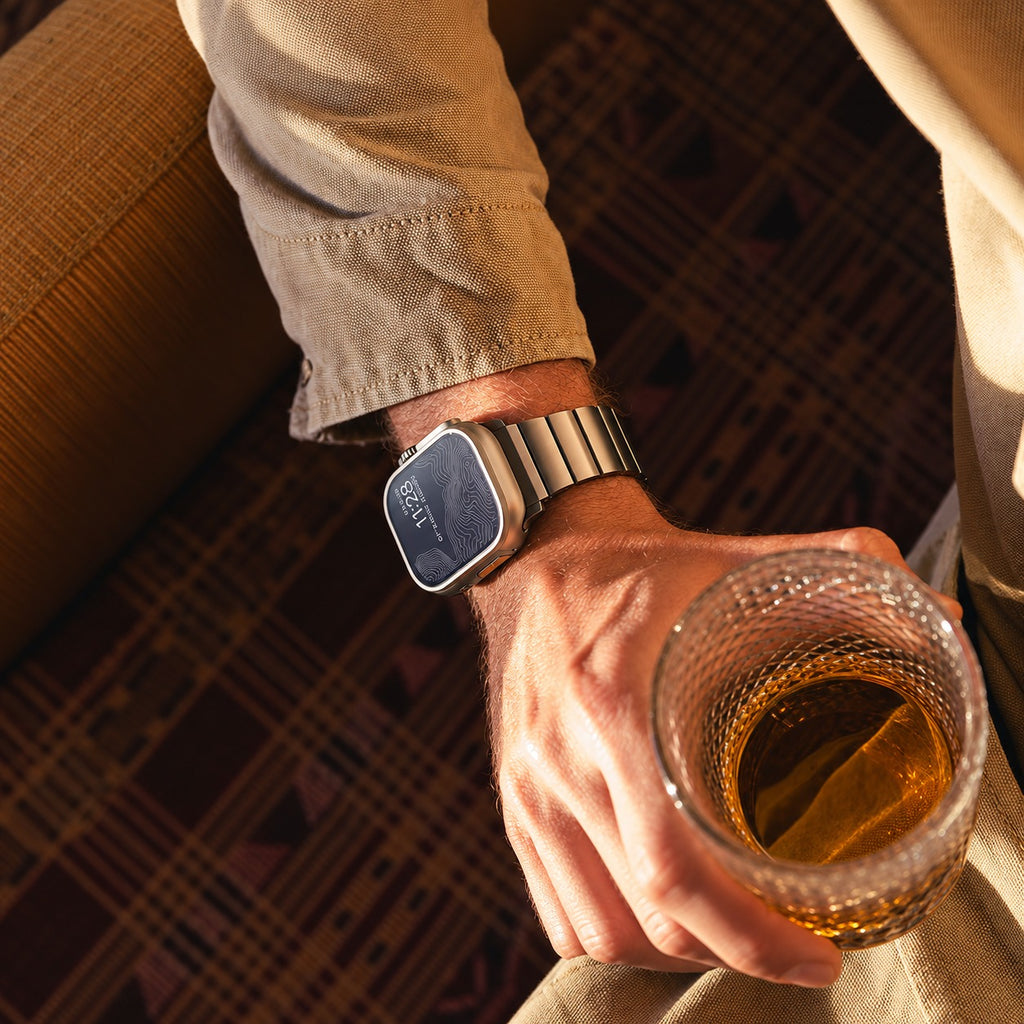 Flat-Link Stainless Steel Band for Apple Watch, Space Gray, worn on the wrist with a drink