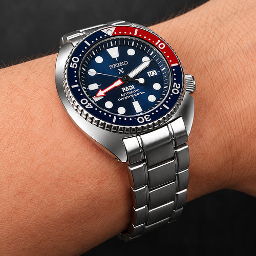 Silver curved end stainless steel bracelet worn on a Seiko Turtle-style dive watch